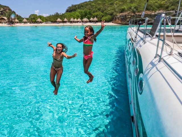 family jumping beach curacao